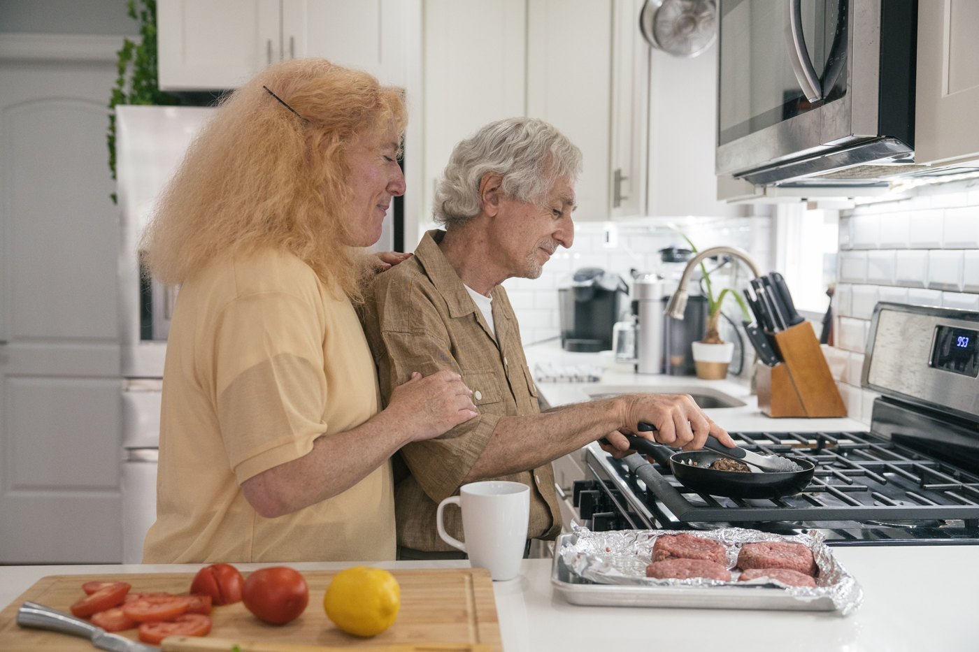 Deux seniors préparent ensemble un repas.